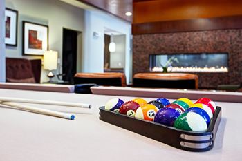 A pool table with a rack of balls and a cue stick.